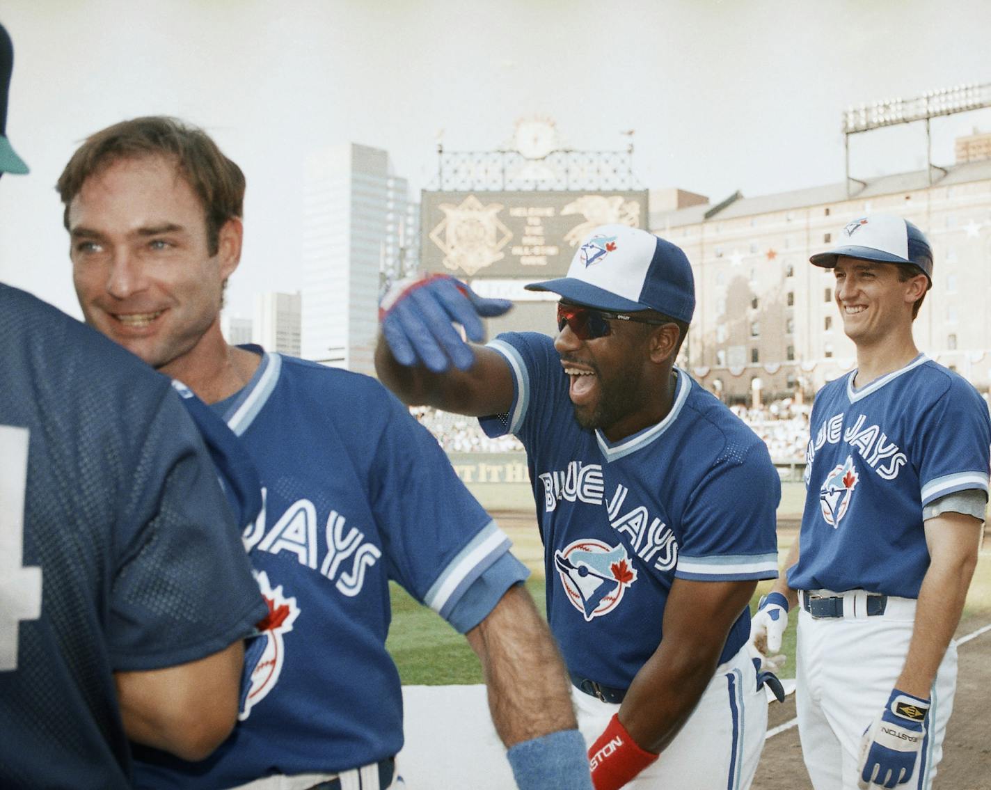 Toronto Blue Jays right fielder Joe Carter, center, playfully slaps teammate Paul Molitor as John Olerud, right, of the Jays looks on before the All Star game, Tuesday, July 13, 1993, Baltimore, Md. (AP Photo/Carlos Osorio) ORG XMIT: APHS179130