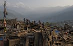 Villagers search rubble for usable items in Barpak, a village at the epicenter of the earthquake where more than 1,200 houses were destroyed or damage