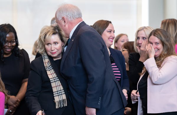 Gov. Tim Walz hugged First Lady Gwen Walz as tears ran down her face. On the right are Rep. Carlie Kotyza-Witthuhn, DFL-Eden Prairie and Sen. Jennifer