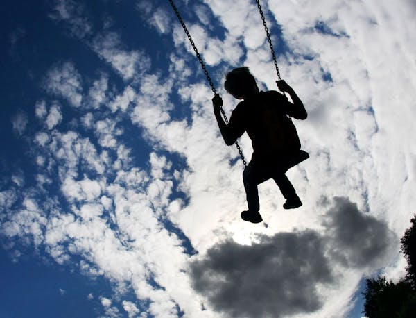 A child swings under a blue sky with clouds on a playground in Frankfurt, Germany, Thursday, July 12, 2012. Sun, rain, wind and cold temperatures are 