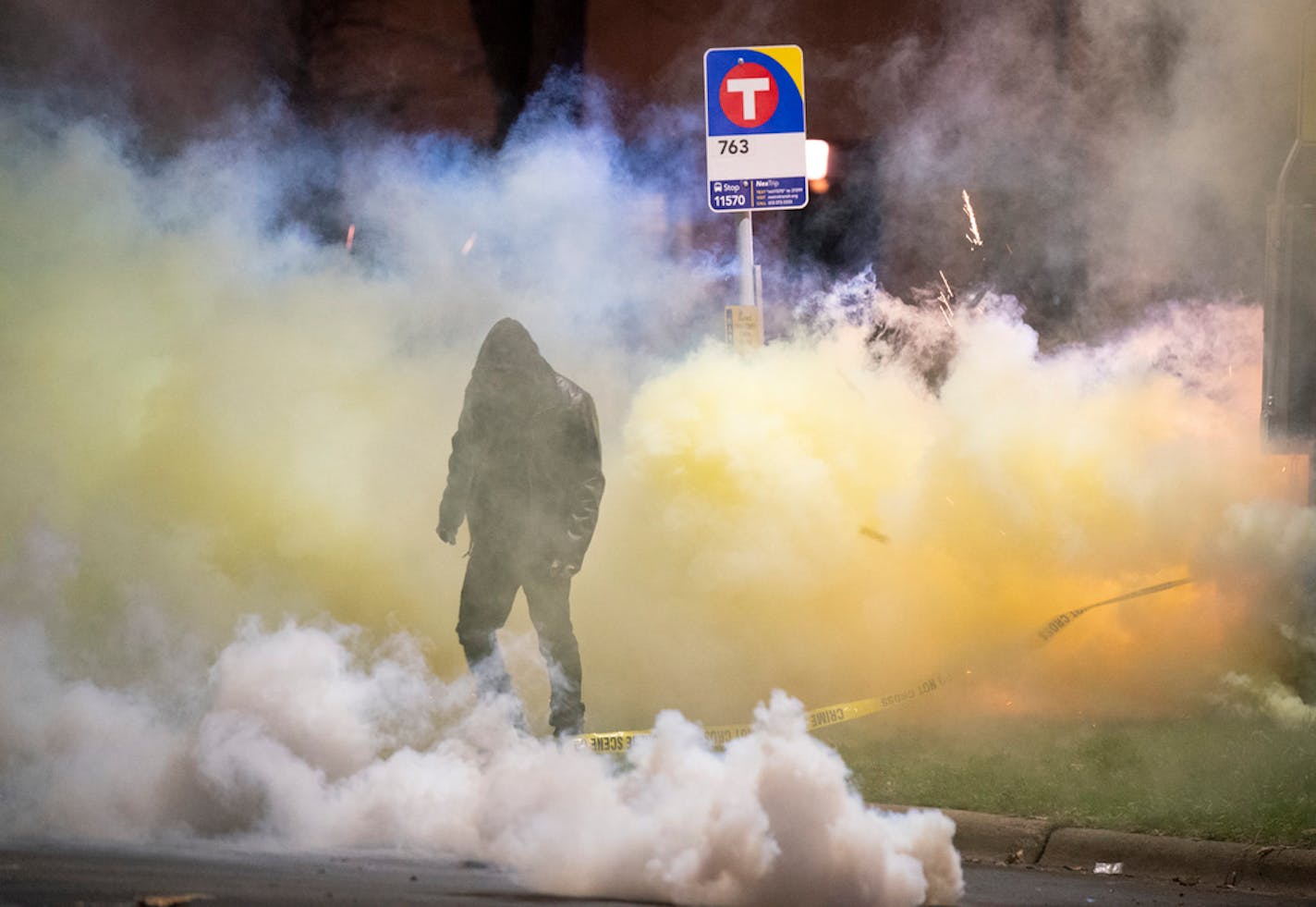 A demonstrator walked amid the tear gas emitted from canisters outside the Brooklyn Center Police Department Sunday night. ] JEFF WHEELER • jeff.wheeler@startribune.com