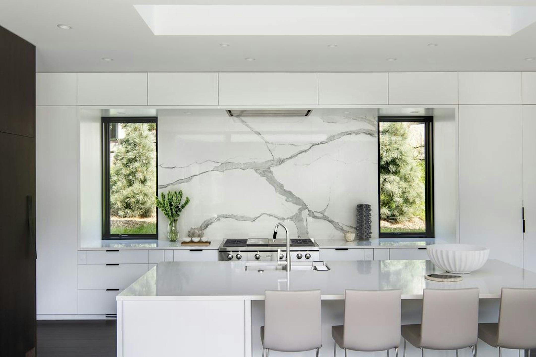 Kitchen backsplash made of porcelain that mimics the look of a massive slab of veined marble.
