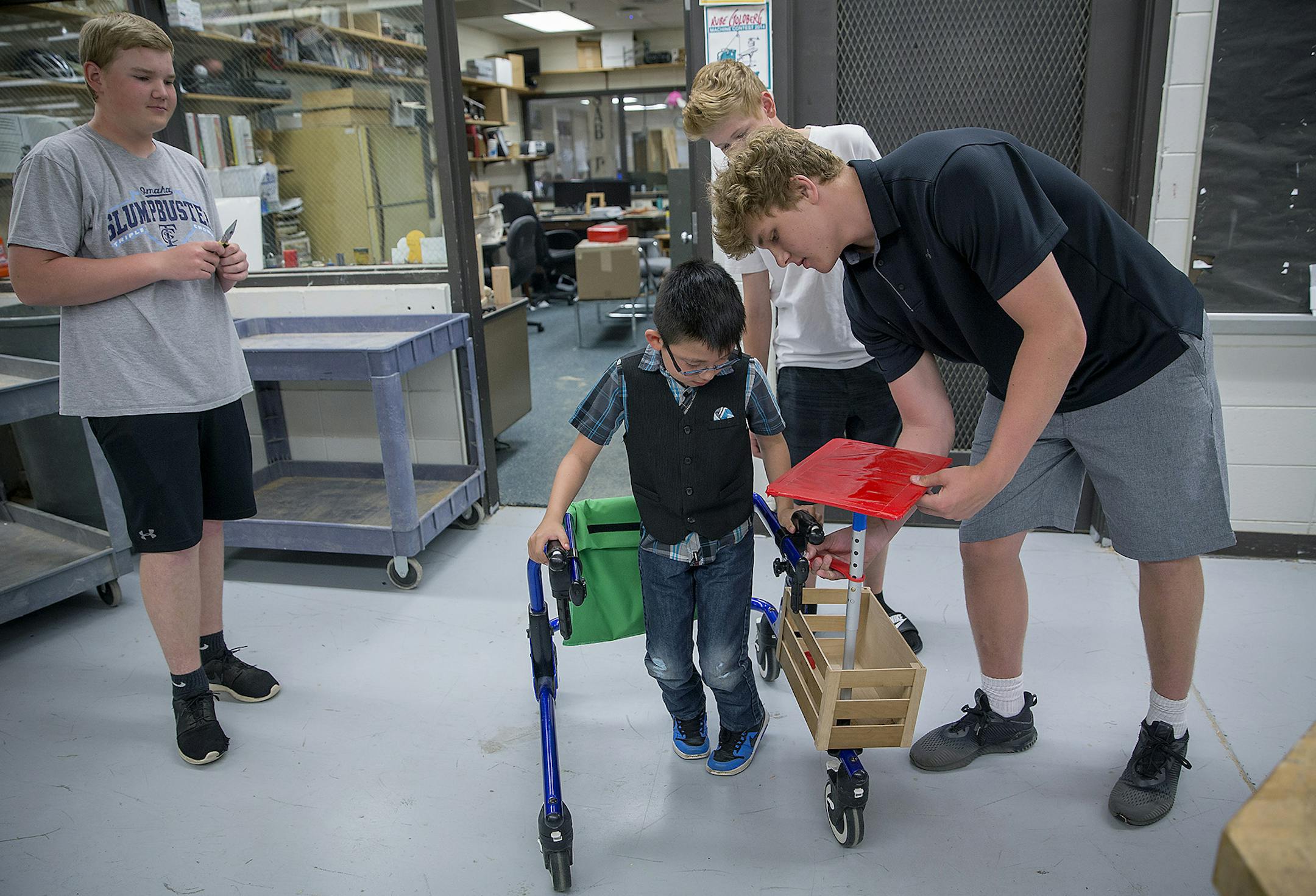 Alex Benitez-Alvarez, 8, was all smiles as he tried out his newly modified walker at East Junior High School, Tuesday, May 29, 2018 in Shakopee, MN. Ethan Hintz, left, Jake Hallett, center, and Tommy Johnson, created a "box" for Benitez-Alvarez, who needed more storage space on his walker to carry school items. ] ELIZABETH FLORES &#xef; liz.flores@startribune.com
