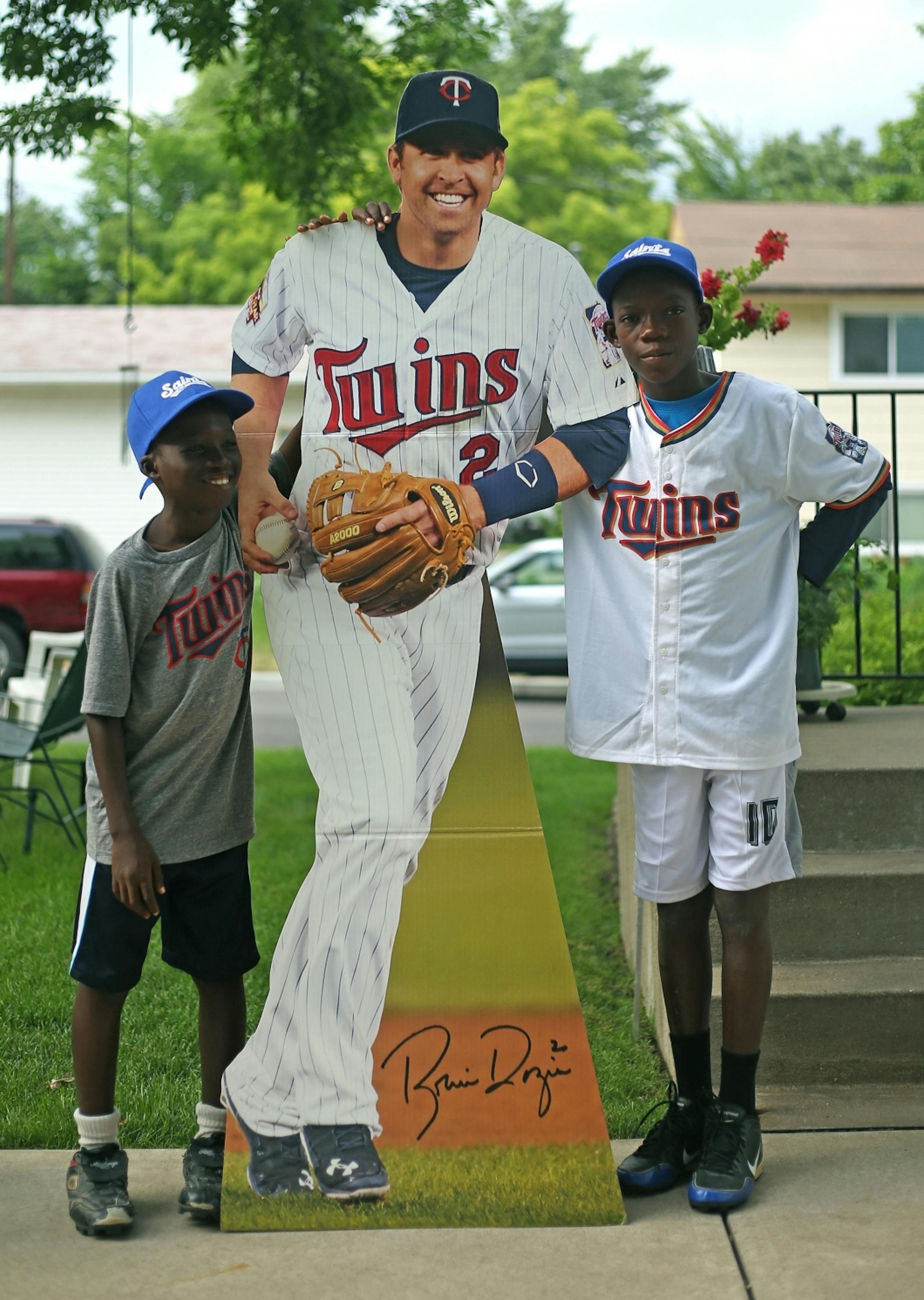 Hospice Acakpo, left, and Fidele Akakpo, right, pose with a cardboard cutout of Minnesota Twins second baseman Brian Dozier at the house of volunteers Tim and Diane Keefe on Monday, August 1, 2016 in Robbinsdale.