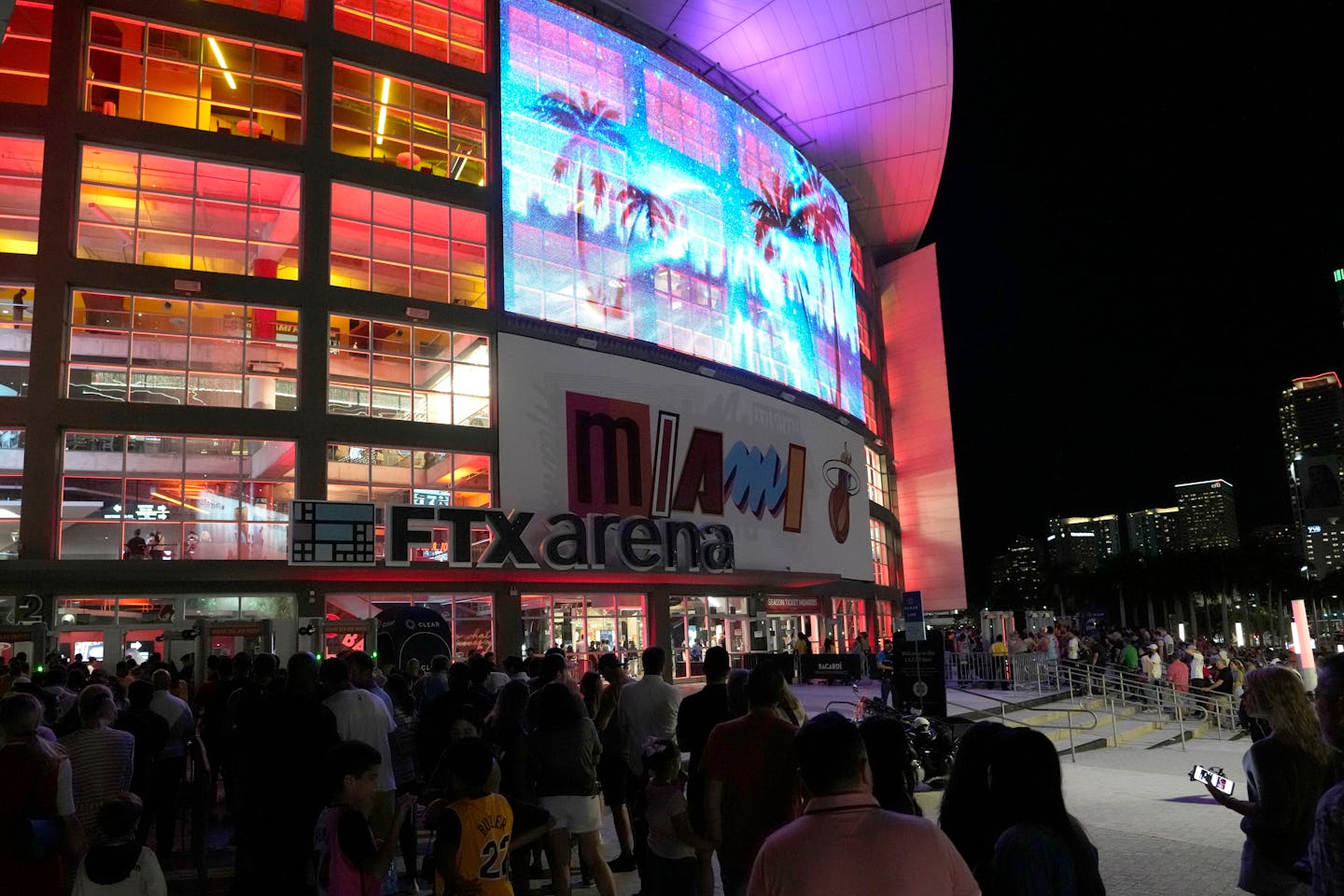 People stand in line outside of the FTX Arena, where the Miami Heat NBA basketball team play, Tuesday, Dec. 6, 2022, in Miami. (AP Photo/Lynne Sladky)