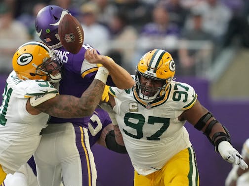 Minnesota Vikings quarterback Kirk Cousins (8) fumbled the ball as he was sacked by Green Bay Packers outside linebacker Preston Smith (91) and nose tackle Kenny Clark (97) in the third quarter.