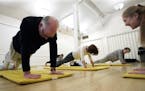 Donna Pointer, right, a yoga instructor for 30 years, gives words of encouragement to 76-year-old Webster Smith doing a stretch, as she leads a group 