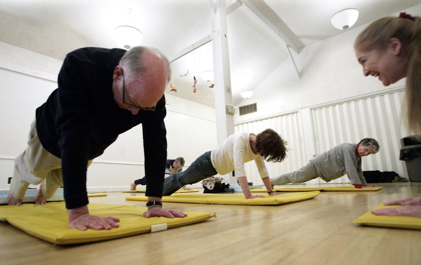 Donna Pointer, right, a yoga instructor for 30 years, gives words of encouragement to 76-year-old Webster Smith doing a stretch, as she leads a group of senior citizens in her weekly class on Tuesday, April 4, 2006 at the Senior Center in Ann Arbor, Mich. (AP Photo/Tony Ding) ORG XMIT: NY722