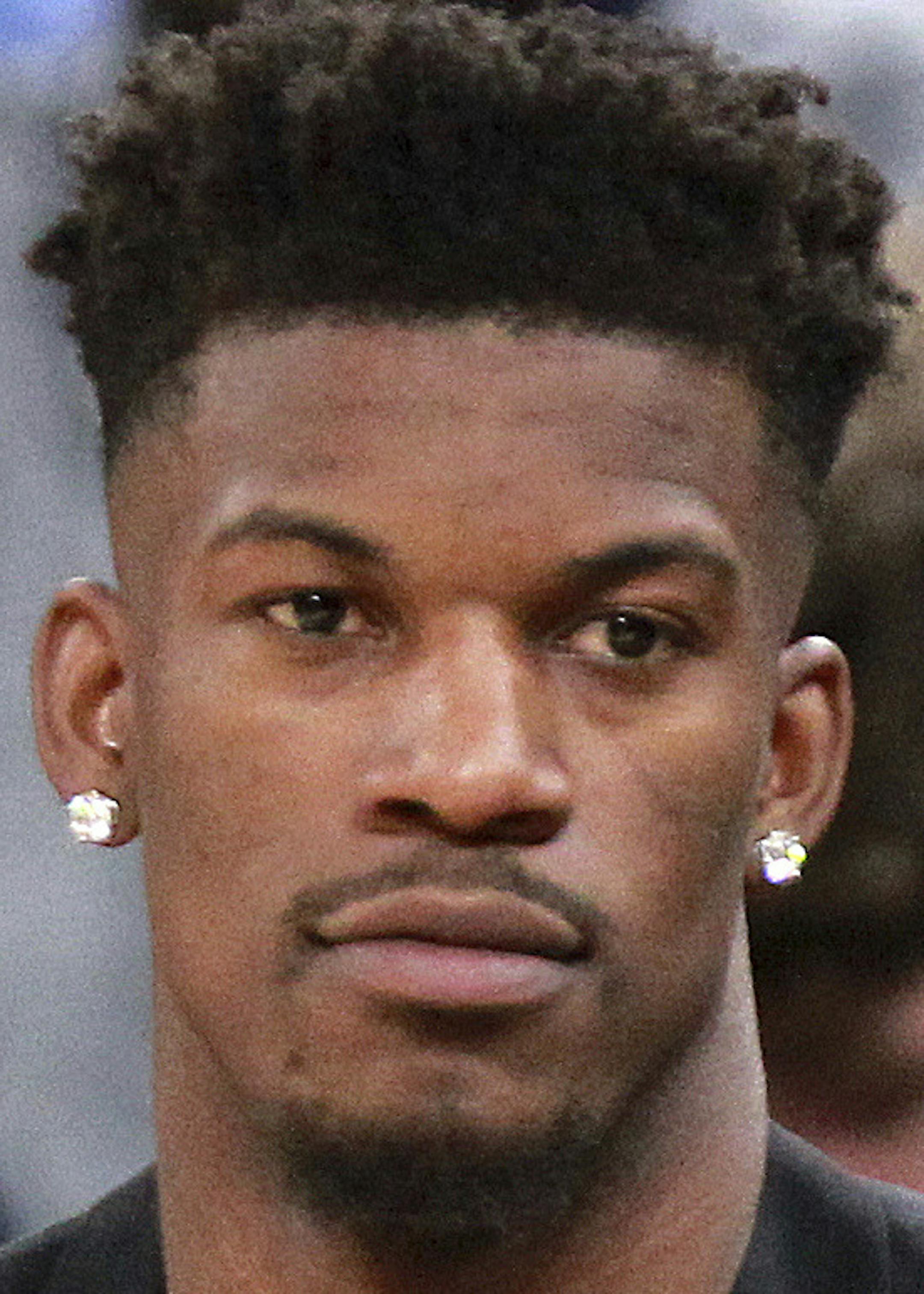 Injured Minnesota Timberwolves guard Jimmy Butler tosses the game ball official Ed Malloy (14) during a time out against the Houston Rockets in the third quarter of an NBA basketball game Sunday, March 18, 2018, in Minneapolis. (AP Photo/Andy Clayton-King)
