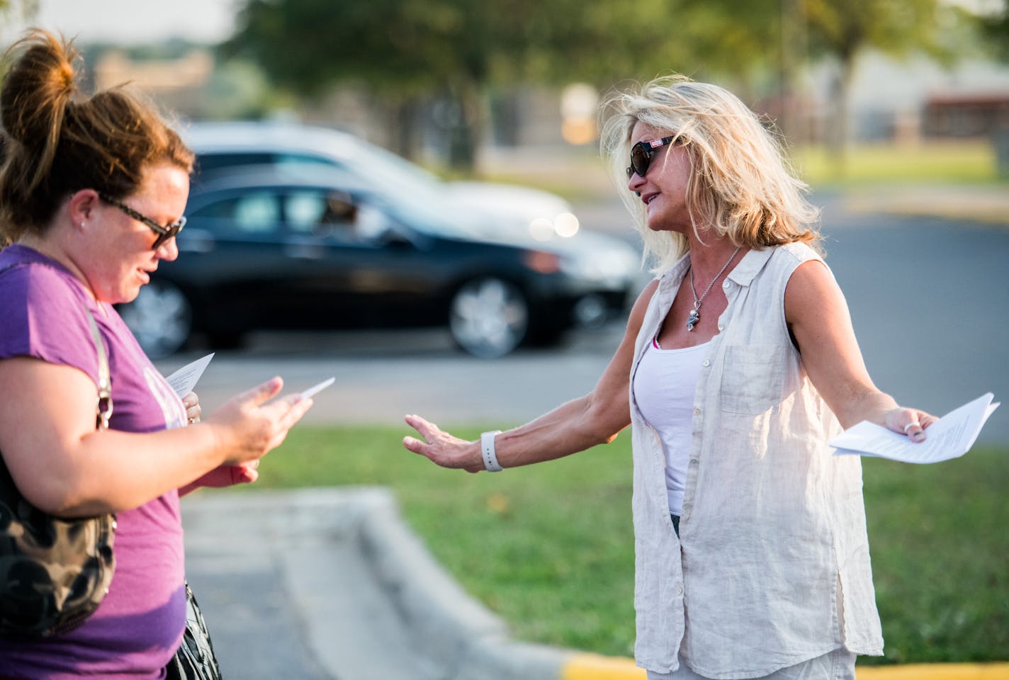 Kristine Robinson handed out literature on the group's fiscal investigation of the school board to parents and residents.