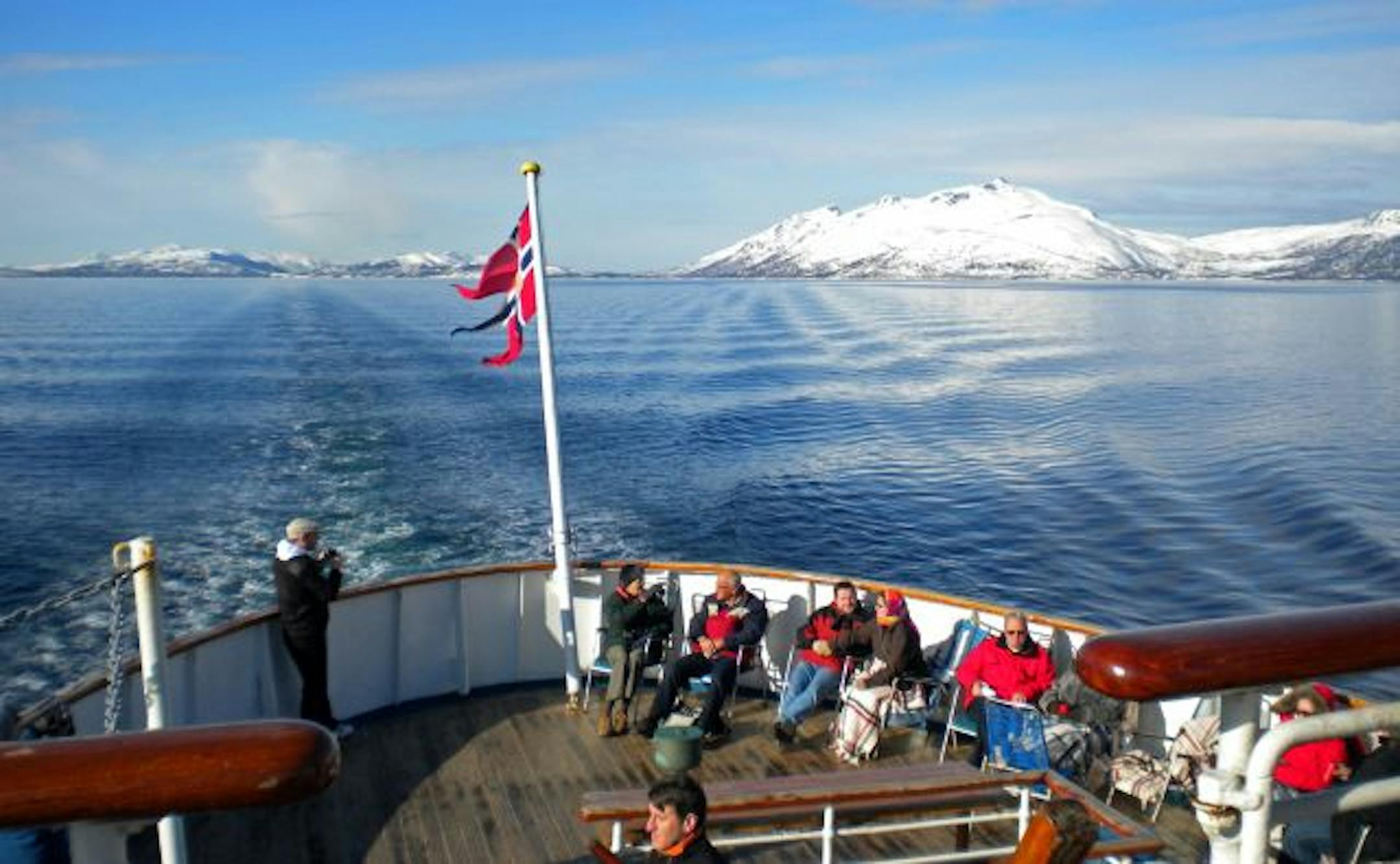 Passengers take in the view of the coast above the Arctic Circle from the deck of the Nordstjernen. The relaxed pace aboard ship affords large chunks of time to settle in to the deck chairs.