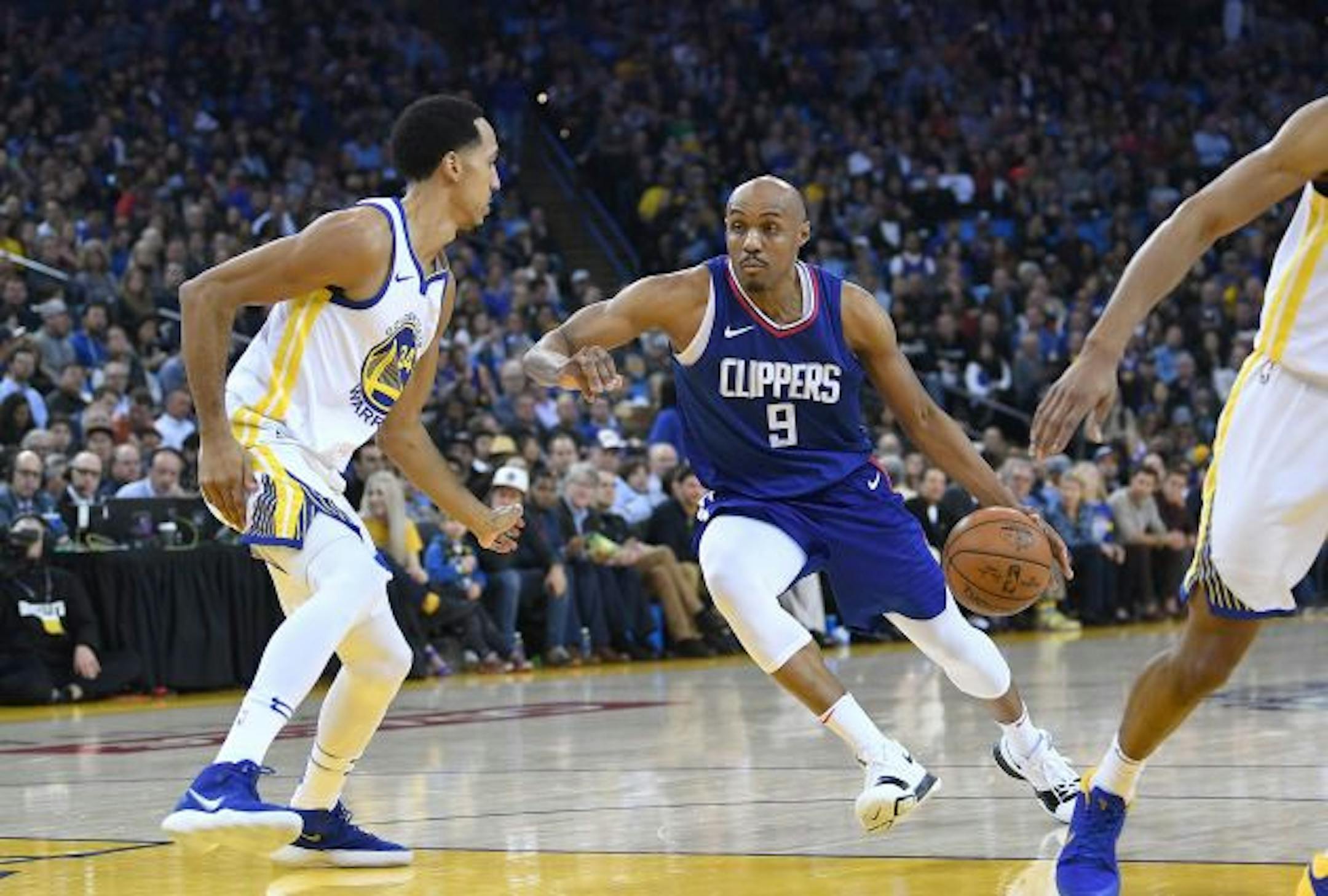 OAKLAND, CA - JANUARY 10:  C.J. Williams #9 of the LA Clippers drives towards the basket on Shaun Livingston #34 of the Golden State Warriors during the first half of their NBA Basketball game at ORACLE Arena on January 10, 2018 in Oakland, California. NOTE TO USER: User expressly acknowledges and agrees that, by downloading and or using this photograph, User is consenting to the terms and conditions of the Getty Images License Agreement.  (Photo by Thearon W. Henderson/Getty Images)