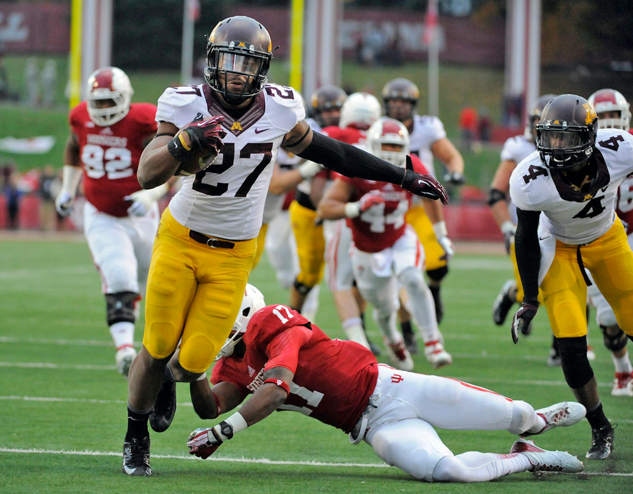 Minnesota's David Cobb (27) runs as Indiana's Michael Hunter (17) defends during the second half of an NCAA college football game in Bloomington, Ind., Saturday, Nov. 2, 2013. Minnesota won 42-39. (AP Photo/ Alan Petersime)