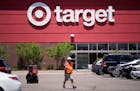 FILE - A worker collects shopping carts in the parking lot of a Target store June 9, 2021, in Highlands Ranch, Colo. Target says it's cutting prices o