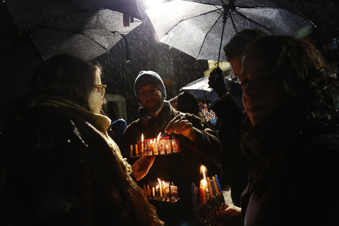 Alex Mizrahi, center, lights a candle on a menorah at a lighting for the last night of Hanukkah in Grand Army Plaza in the Brooklyn borough of New York, Dec. 29, 2019.