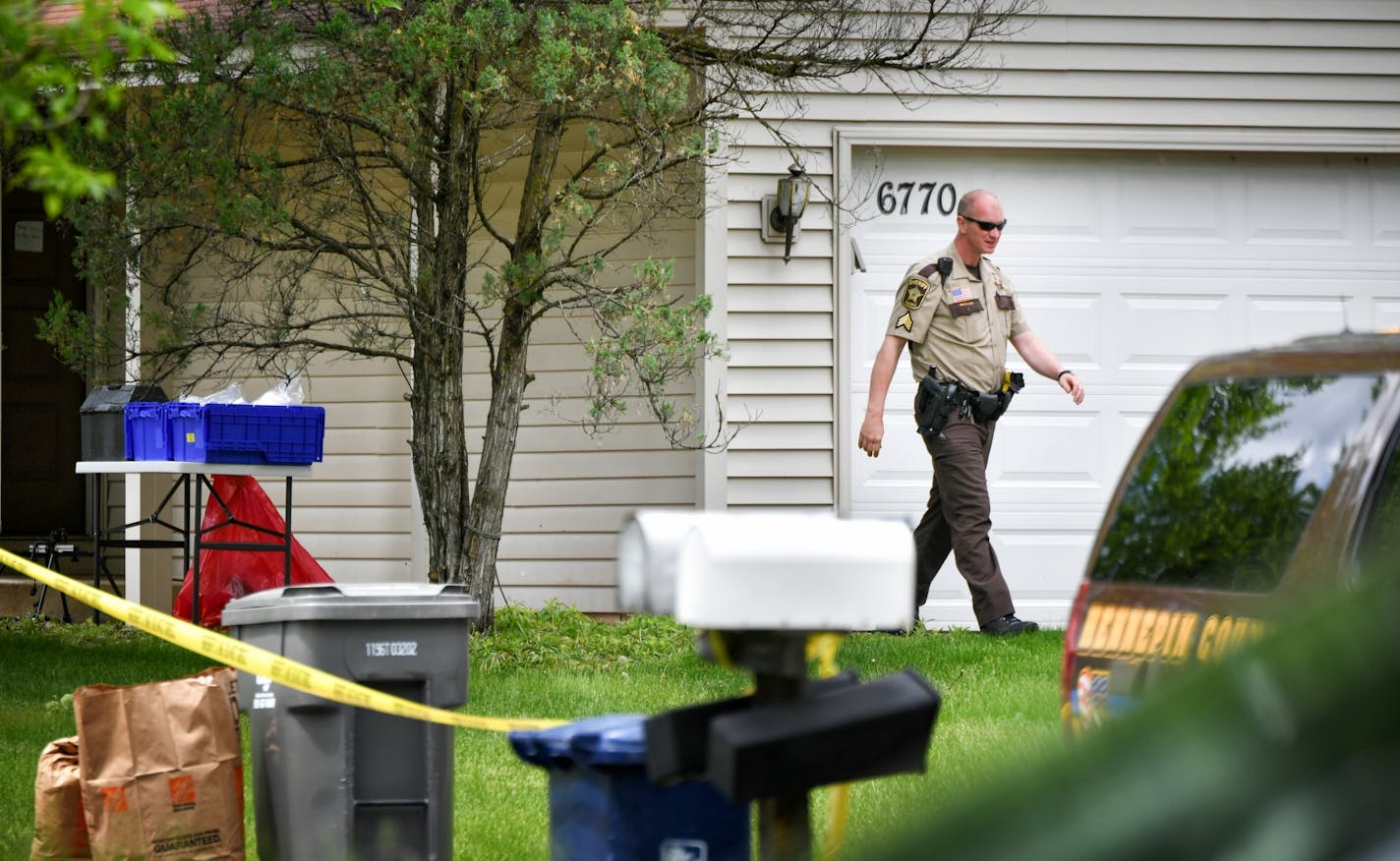 A Hennepin County sheriff's investigator looked around the home in which two bodies were found Thursday morning. The couple's 38-year-old son has been charged with second-degree murder.