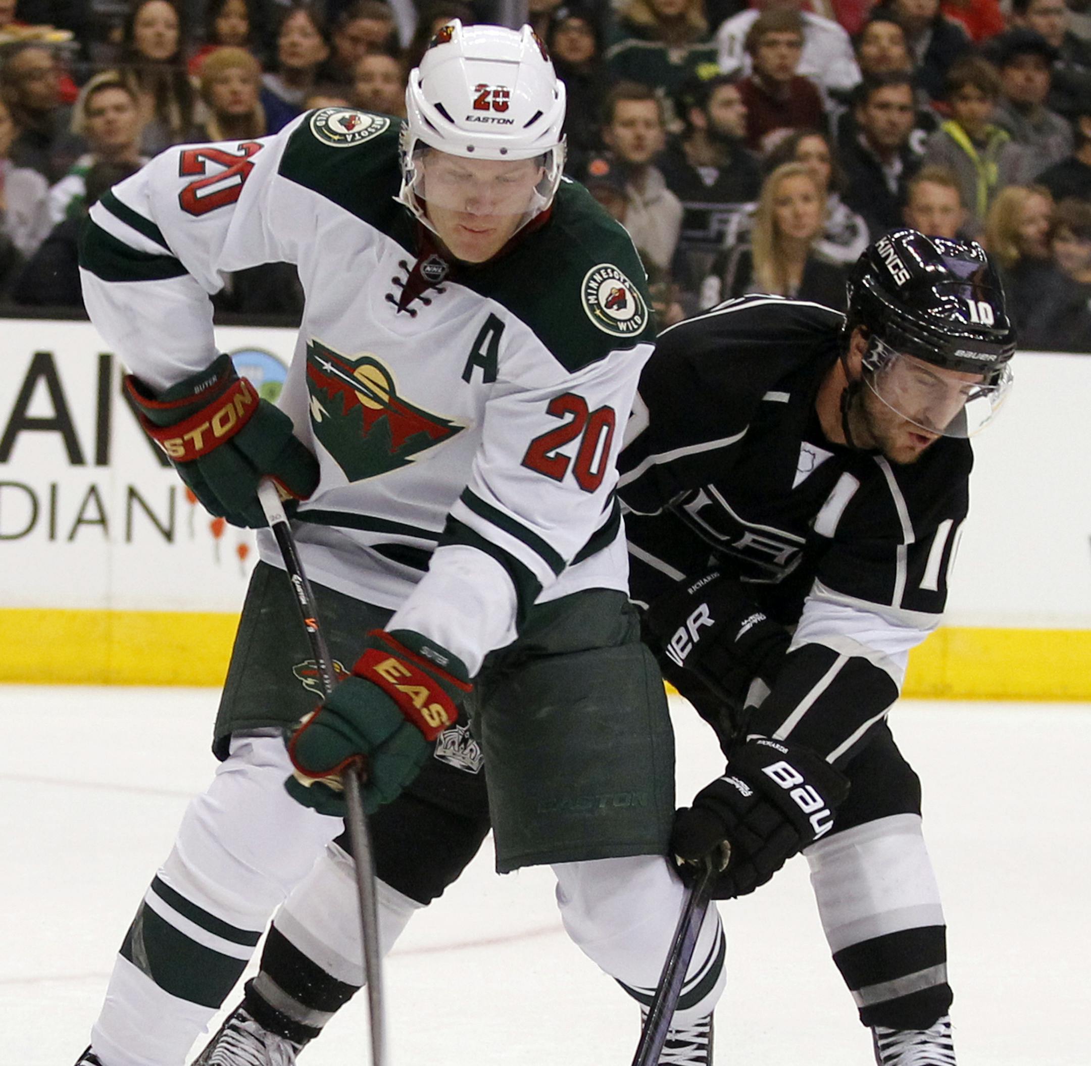 Minnesota Wild defenseman Ryan Suter (20) clears the puck with Los Angeles Kings center Mike Richards (10) in pursuit during the second period of an NHL hockey game Tuesday, Jan. 7, 2014, in Los Angeles. (AP Photo/Alex Gallardo)