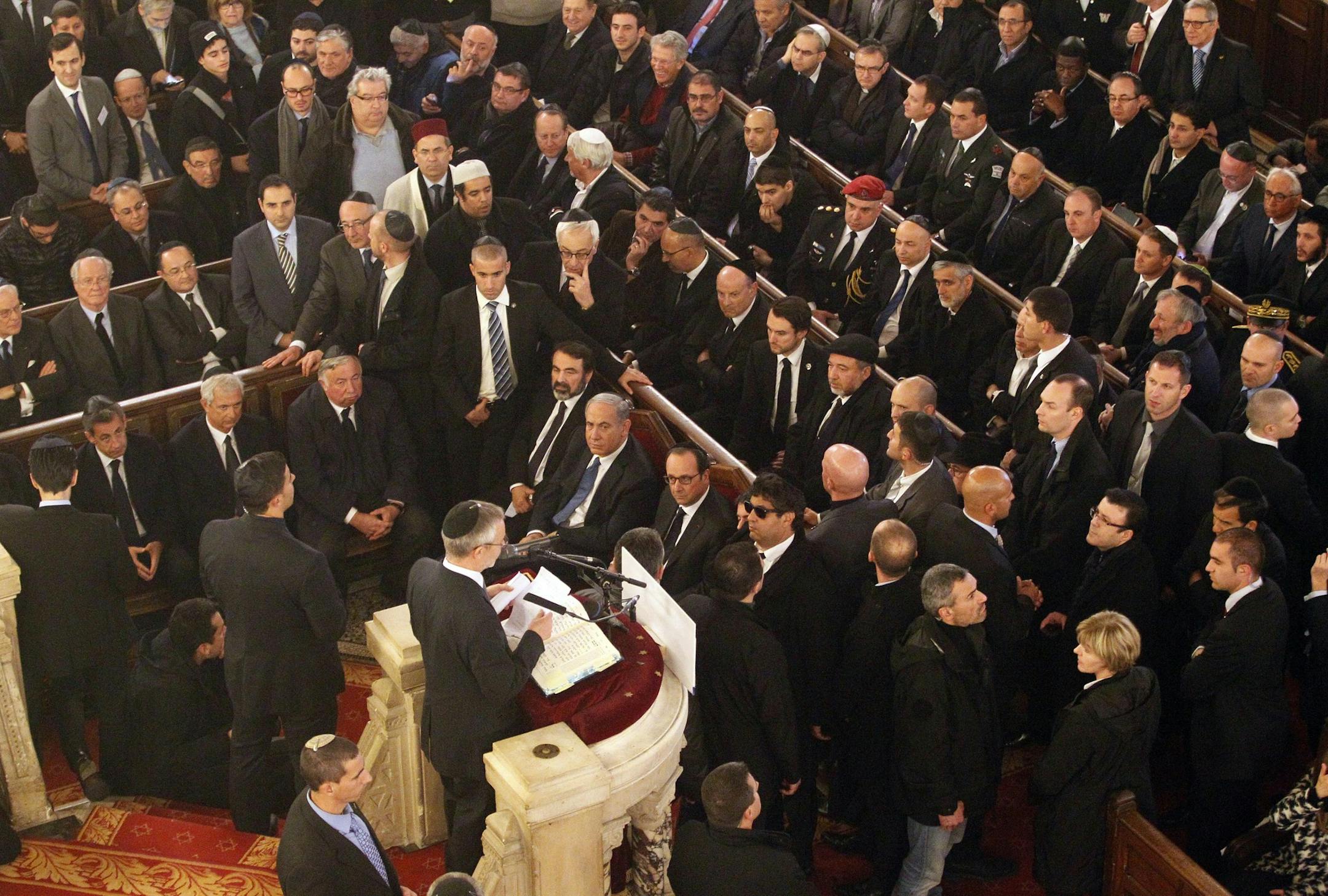 Israel's Prime Minister Benjamin Netanyahu and French President Francois Hollande, front row center, attend a ceremony at the Grand Synagogue in Paris, France, for all the victims of the attacks in Paris this week, which claimed 17 lives, Sunday, Jan. 11, 2015. More than 40 world leaders, their arms linked, marched through Paris Sunday to rally for unity and freedom of expression and to honor 17 victims of three days of terrorist attacks. (AP Photo/Matthieu Alexandre, Pool)