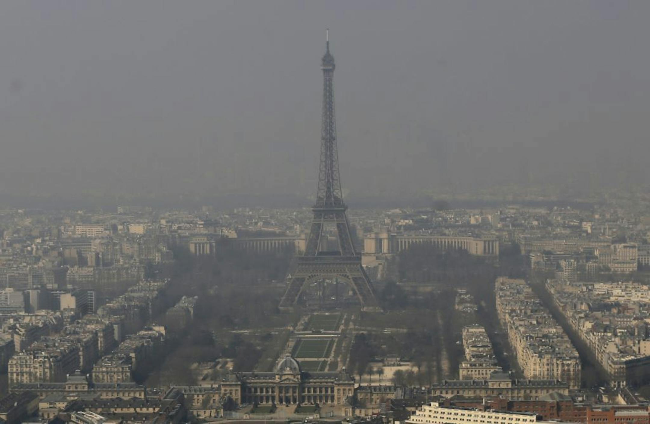 The Eiffel Tower, is barely seen through the smog from Paris, Friday, March 14, 2014.
