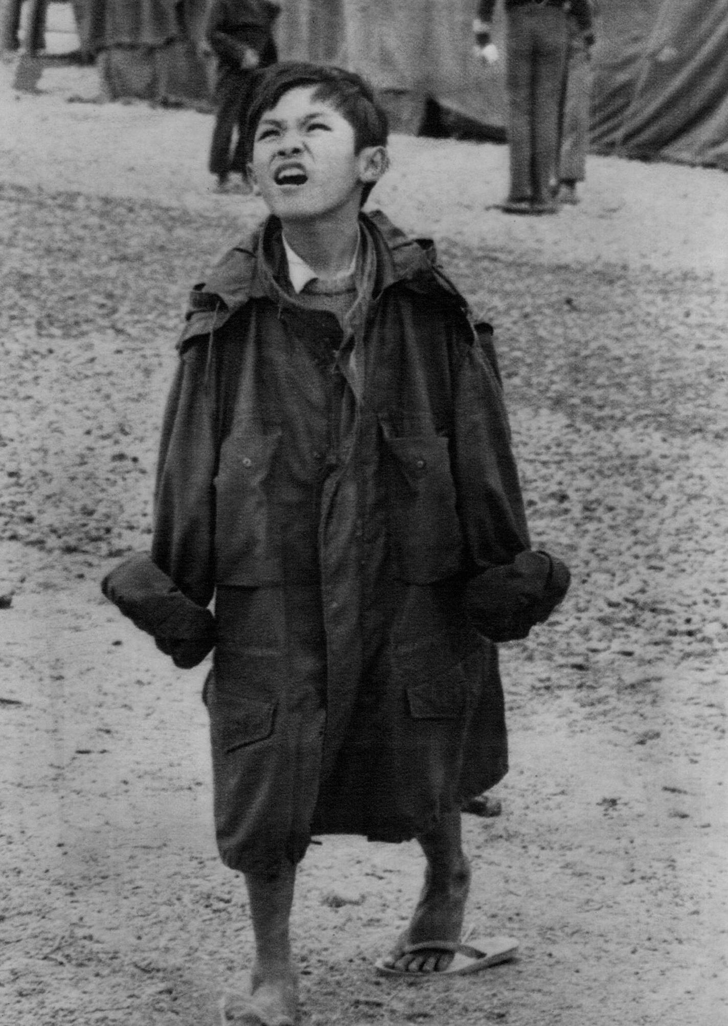 June 17, 1975 DWARFED in an oversized Marine fatigue jacket, an unidentified Vietnamese youngster studied the sky at Camp Pendleton, Calif., and puzzled, "Will the sun ever shine?" The inclement weather has been the biggest complaint of the refugees at Pendleton. There has been much fog and temperatures averaging in the 50s in recent weeks. United Press International