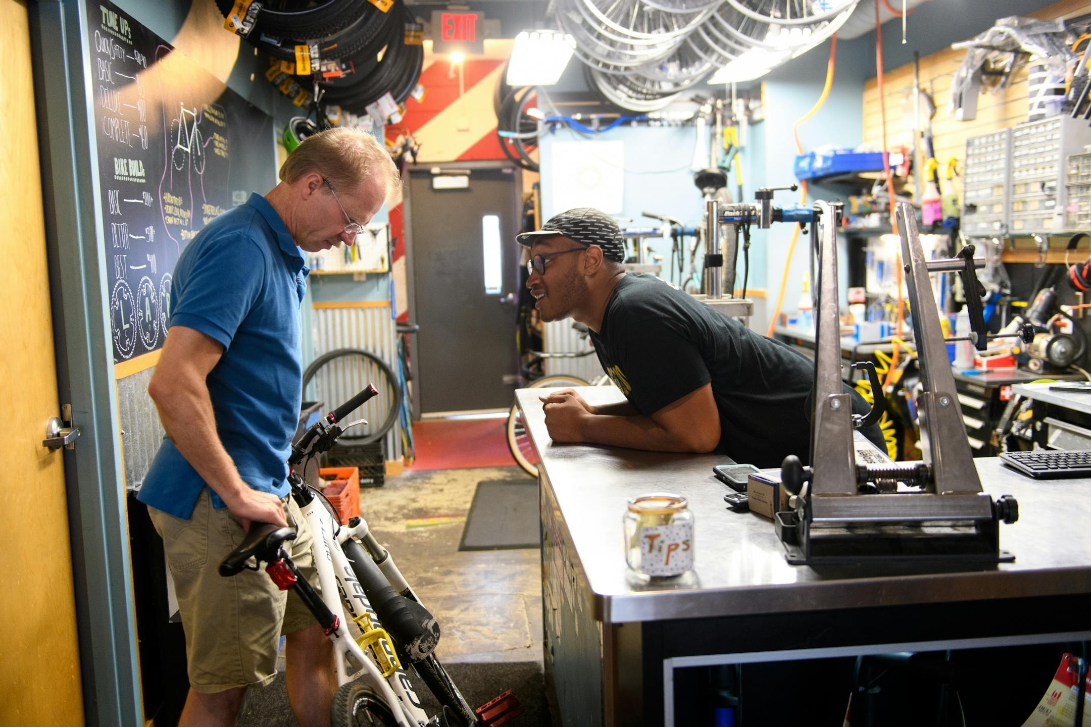 Martin Tschofen, of Robbinsdale, left, was helped by Darrow Jones, right, service manager at Venture North Bikes and Coffee Wednesday night. The bike shop is run by Redeemer Center for Life, the non-profit partner of Redeemer Lutheran Church.