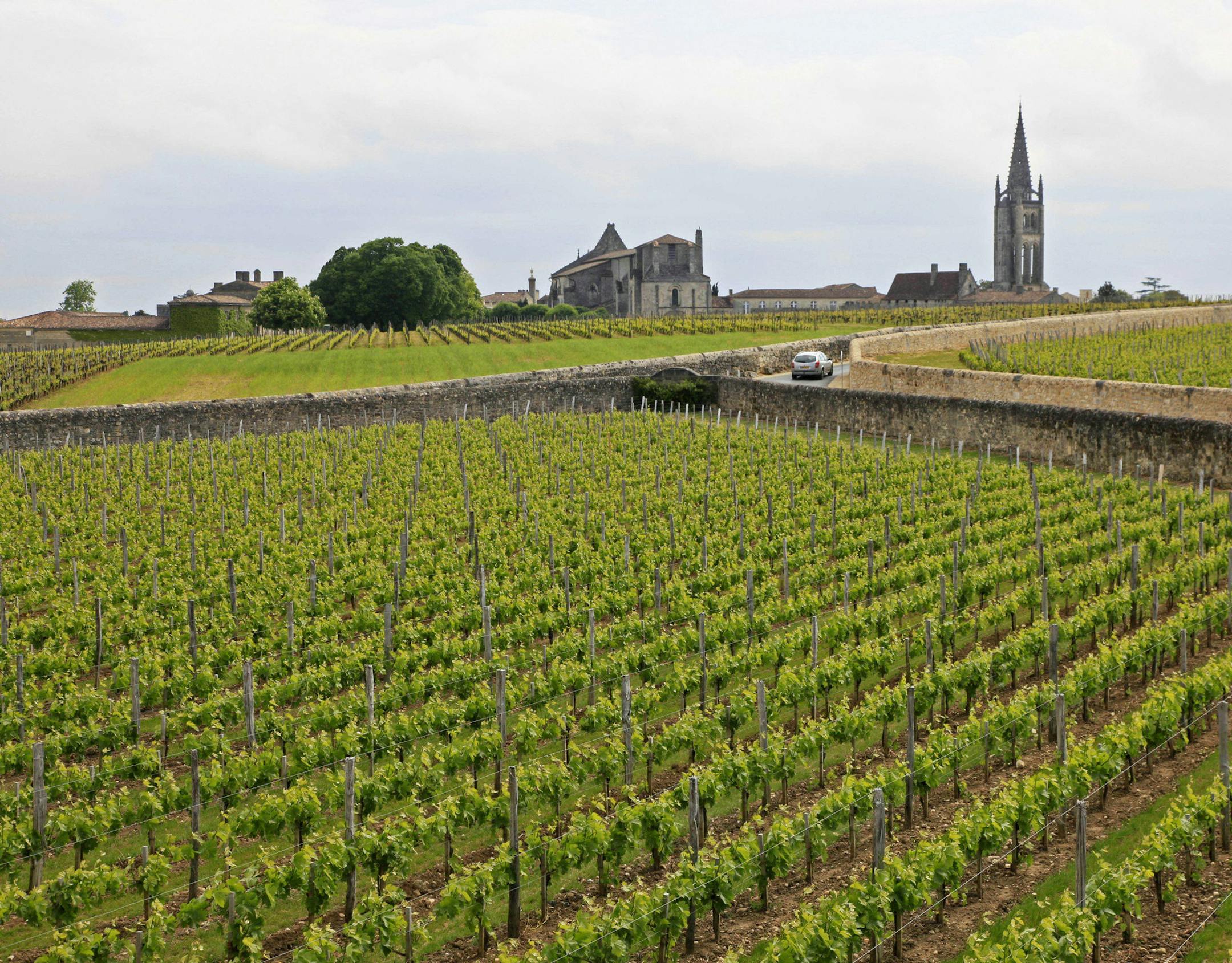 FILE - This May 3, 2010 file photo shows the Vineyards of Chateau Canon, with the medieval commune and monolithic church of St. Emilion in the background, in France. France wants to boost tourism by developing wine and gastronomy tours in its countryside as part of a series of measures that aim at keeping the country&#x2019;s position as the top destination in the world. French foreign affairs minister Laurent Fabius set Thursday a target of 100 million foreign tourists per year by 2020 _from 84