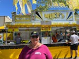 Terri Hohenwald, 60, owns the Mike's Hamburger business at the State Fair with her husband, Mike. She stands in front of the business on Wednesday, Au