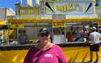 Terri Hohenwald, 60, owns the Mike's Hamburger business at the State Fair with her husband, Mike. She stands in front of the business on Wednesday, Au