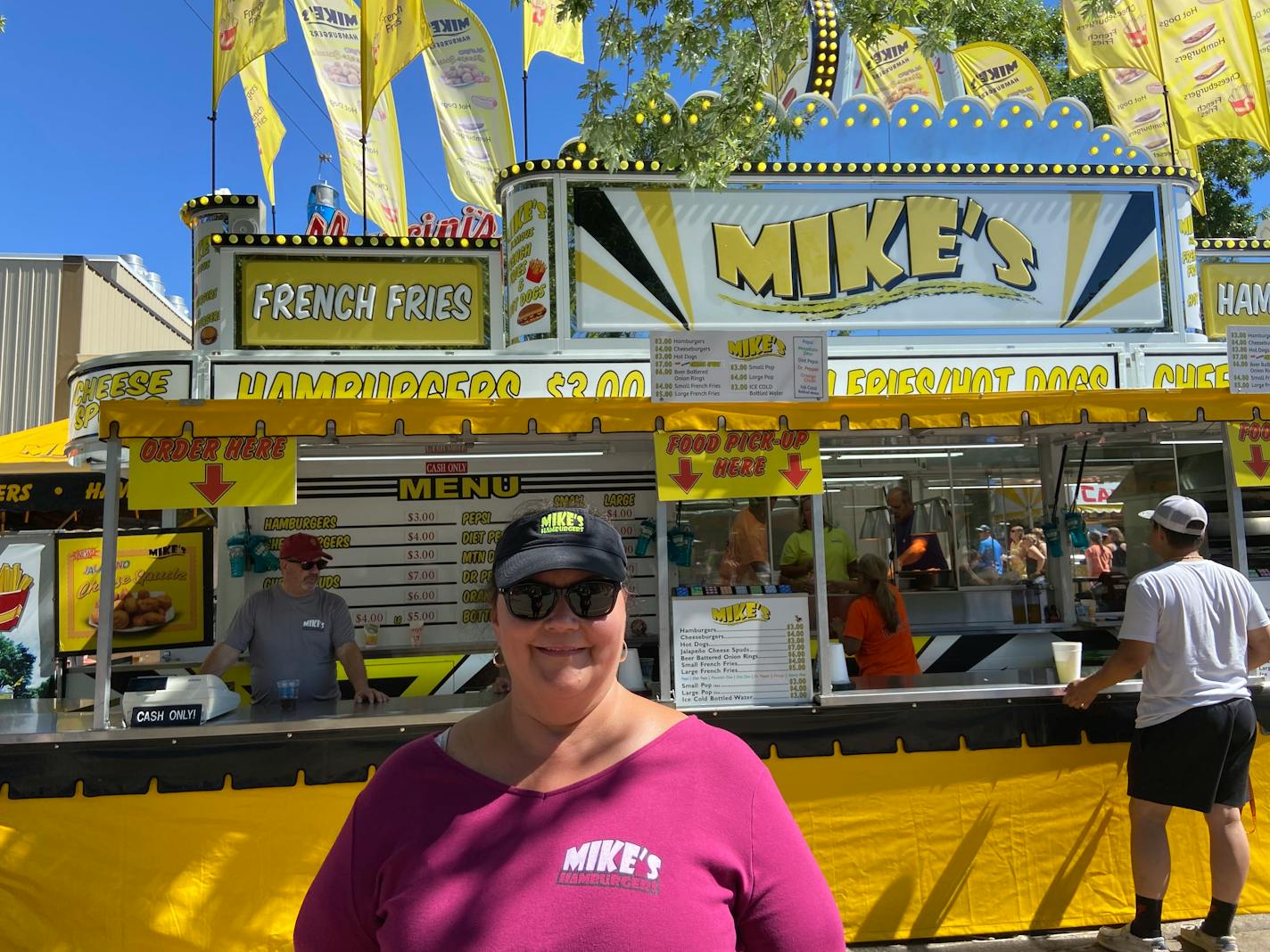 Terri Hohenwald, 60, owns the Mike's Hamburger business at the State Fair with her husband, Mike. She stands in front of the business on Wednesday, August 31, 2022. This year, attendance has significantly increased compared to last year. (Katelyn Vue/Star Tribune)