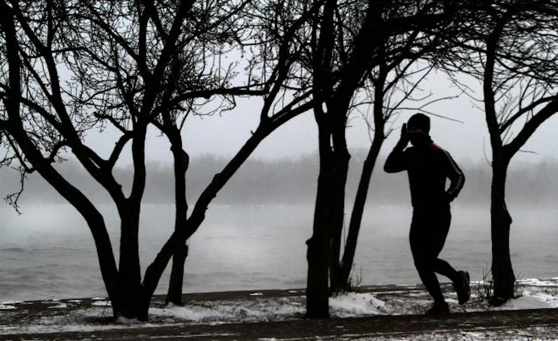 A cold fog wipped across the waters at Lake Harriet as runner jogged around an empty path around the lake.
