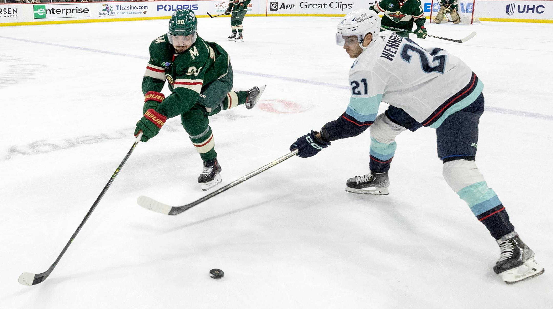 Marcus Johansson (90) of the Minnesota Wild and Alex Wennberg (21) of the Seattle Wild battle for the puck in the second period Monday, March 27, 2023, at Xcel Energy Center in St. Paul, Minn. ] CARLOS GONZALEZ • carlos.gonzalez@startribune.com.