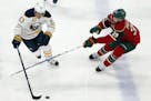 Buffalo Sabres' Tyler Ennis, left, controls the puck against Minnesota Wild's Nate Prosser in the first period of an NHL hockey game Tuesday, Nov. 1, 