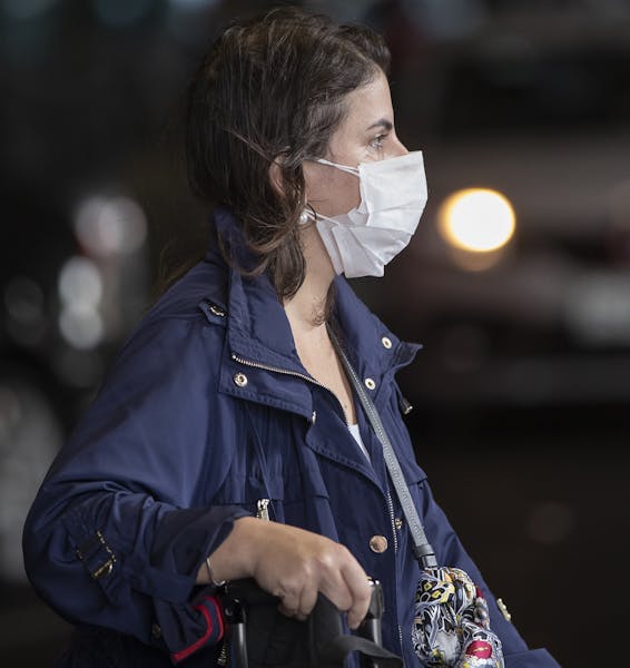 A passenger wearing a mask as a precaution against the spread of the new coronavirus COVID-19 arrives to the Sao Paulo International Airport in Sao Pa