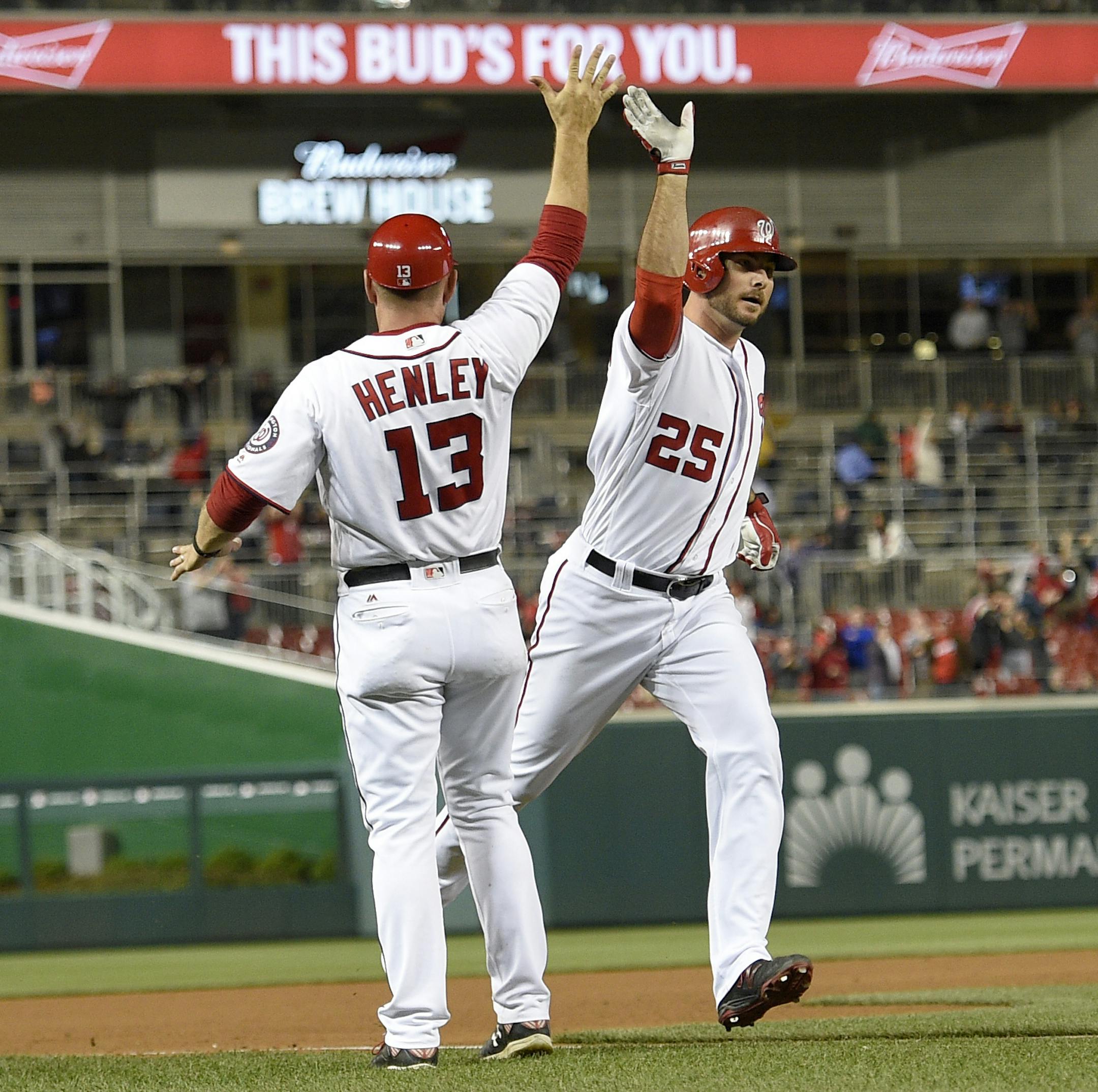 Washington Nationals' Clint Robinson (25) high fives third base coach Bob Henley (13) as he rounds the bases after he hit a walk off home run during the ninth inning of an interleague baseball game against the Detroit Tigers, Monday, May 9, 2016, in Washington. The Nationals won 5-4. (AP Photo/Nick Wass)