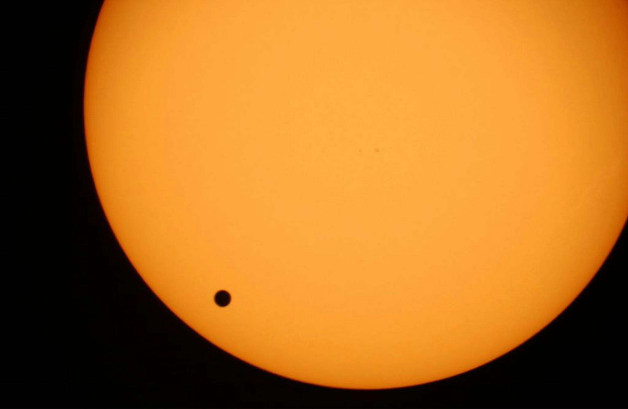 The planet Venus, black spot, crossing the sun is photographed through a telescope at Planetarium Urania in Hove, Belgium.