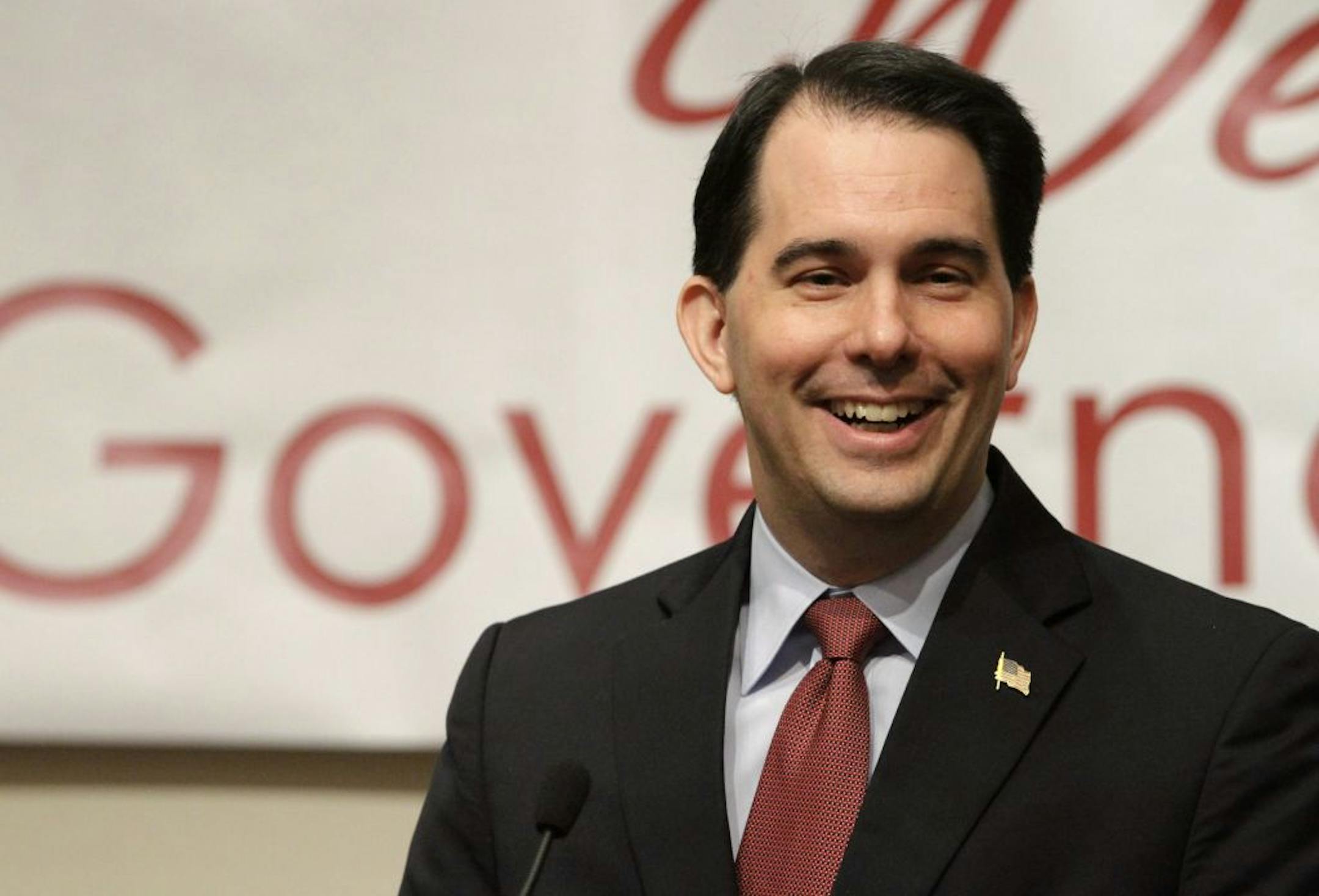 In this April 17, 2012, photo Wisconsin Gov. Scott Walker speaks to the Illinois Chamber of Commerce in Springfield, Ill. An analysis of data by The Associated Press shows Walker quietly reinstated a program to give merit raises and bonuses to over 200 state workers even as he preached cost-cutting and pushed through a law reducing most public workers' pay and eliminating their union rights.