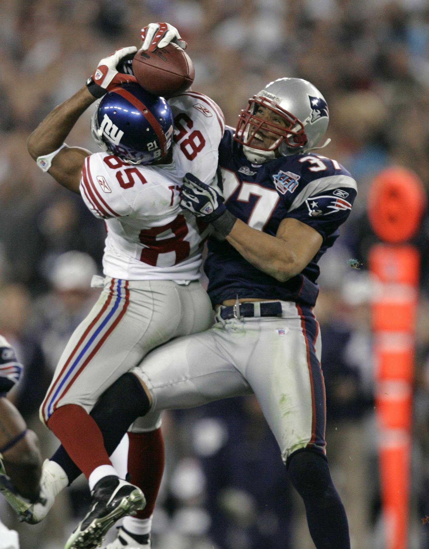 FILE - In this Feb. 3, 2008, file photo, New York Giants receiver David Tyree (85) catches a 32-yard pass in the clutches of New England Patriots safety Rodney Harrison (37) during the fourth quarter of NFL football's Super Bowl XLII in Glendale, Ariz. The Giants won 17-14. (AP Photo/Gene Puskar, File)