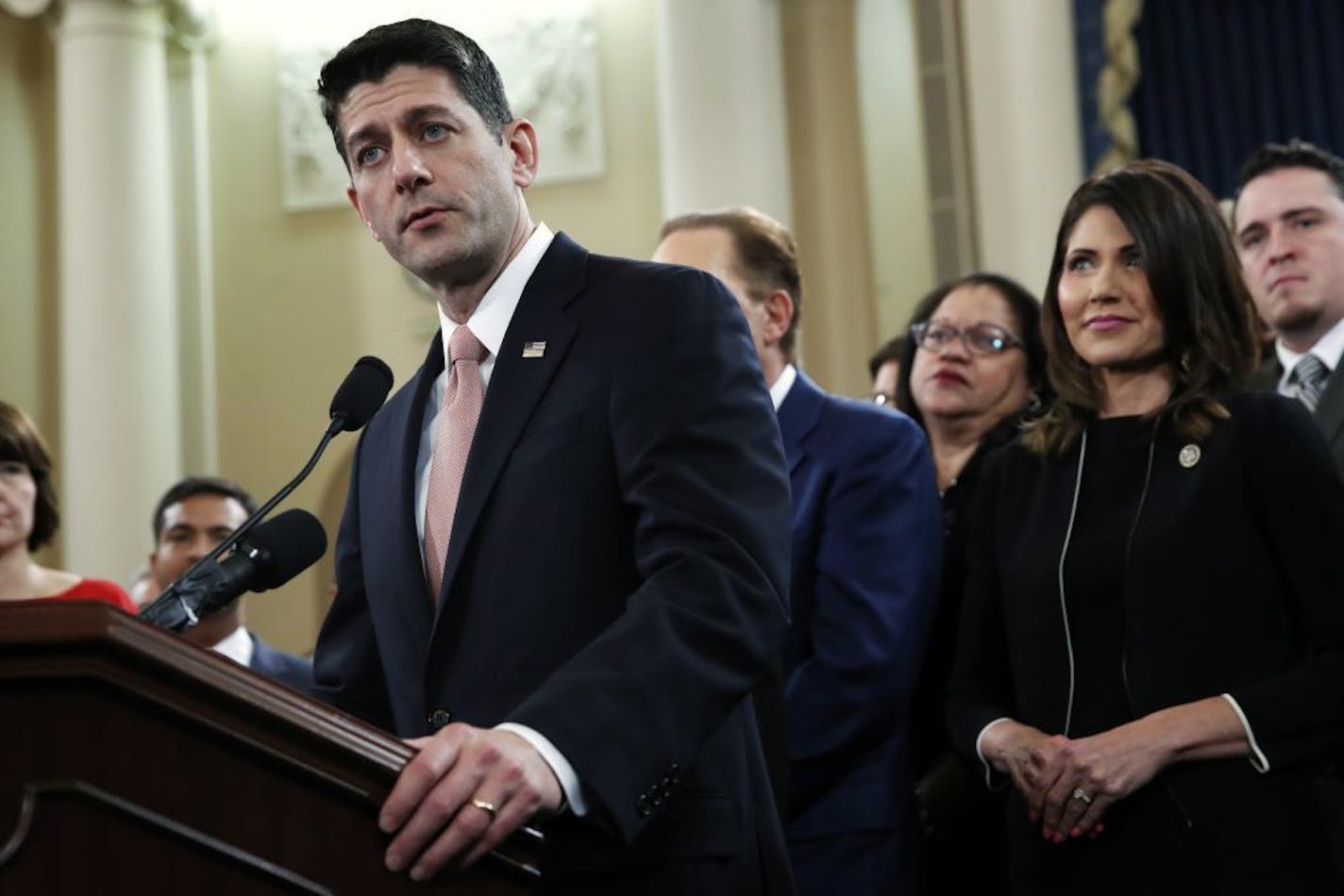 House Speaker Paul Ryan of Wis., left, speaks next to Rep. Kristi Noem, R-S.D., during a news conference announcing the GOP tax overhaul Thursday in Washington.