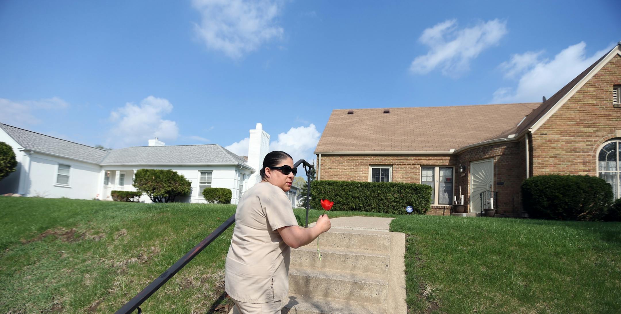 Beth Mejia who grew up in N. Minneapolis dropped a flower of at a home in the 1200 block of Russell avenue N, that is the home where Prince lived as a kid Thursday April 21, 2016 Minneapolis, MN.