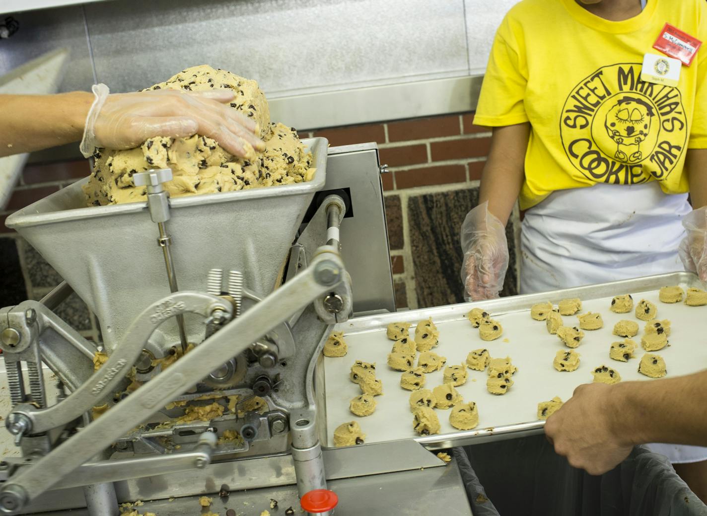 Sweet Martha&#x2019;s employees processed chocolate chip cookie dough through the dolloping machine. The dough comes together partly by trial and error and partly by intuition.