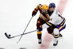Minnesota's Ben Meyers (39) and Minnesota State ma's Ryan Sandelin (14) vie for the puck during the second period of an NCAA men's Frozen Four college