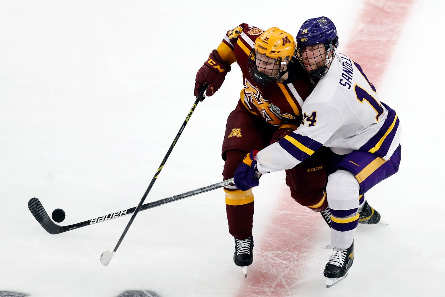 Minnesota's Ben Meyers (39) and Minnesota State ma's Ryan Sandelin (14) vie for the puck during the second period of an NCAA men's Frozen Four college hockey semifinal Thursday, April 7, 2022, in Boston. (AP Photo/Michael Dwyer)