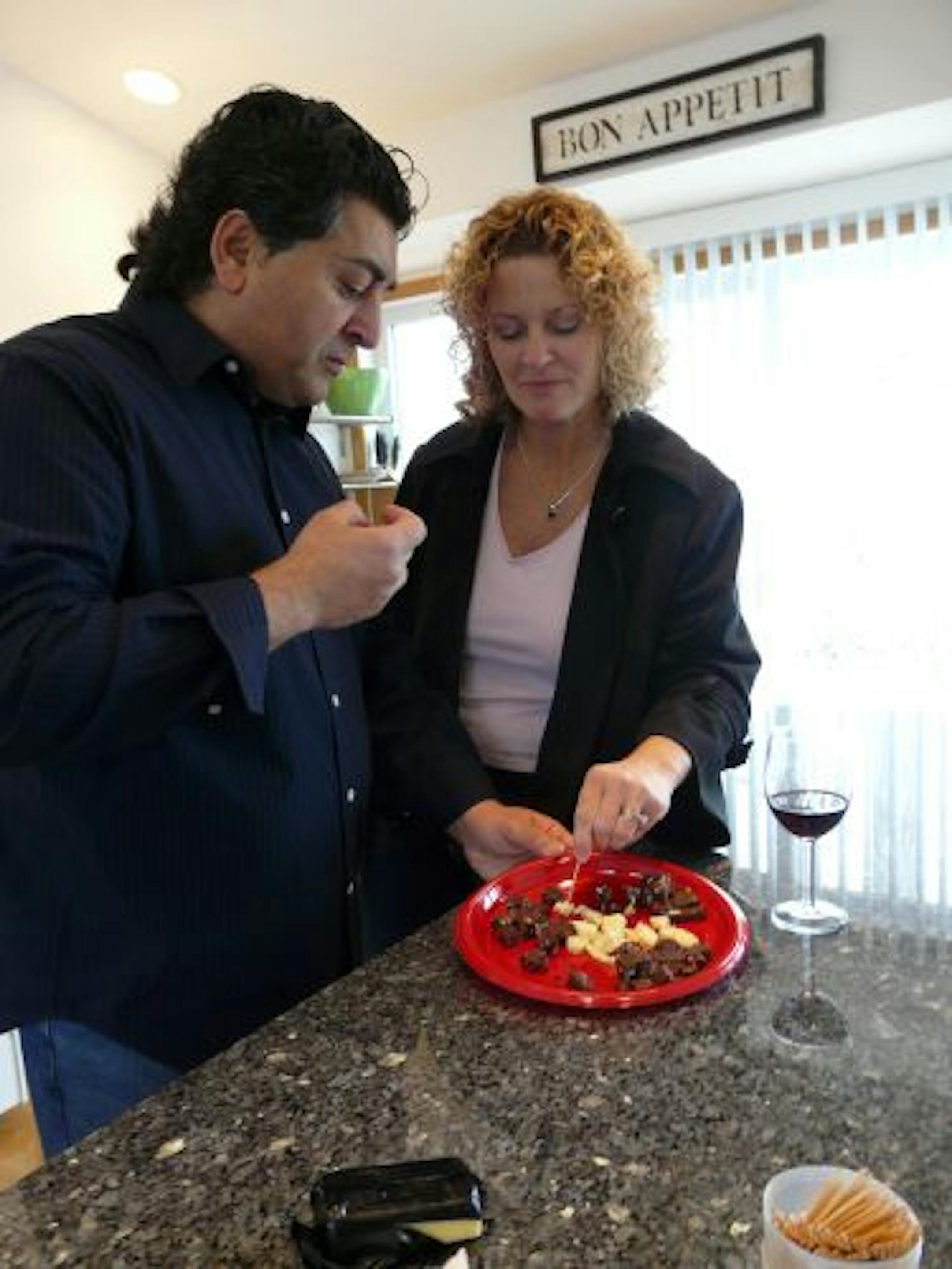 A glass of red wine and cheddar cheese go well with French Nugget artisan chocolates made by Fred and Laurie Golchin in their home in Burnsville.