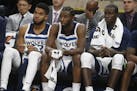 Minnesota Timberwolves' Karl-Anthony Towns, left, Andrew Wiggins, center, and Gorgui Dieng of Senegal watch from the bench late in the fourth quarter 
