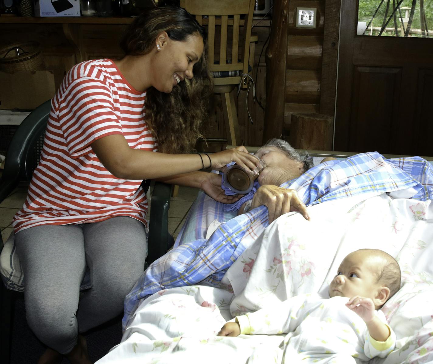 Simone Jarvis helps take care of her grandmother, Ellen Starkka, 83, at their home in Crosslake while her baby Oscar Camacho, 2 months, rests. Starkka's family says a court-appointed guardian neglected her and tried to move her to a nursing home agaist her wishes.