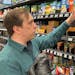 Stuart Dryden reaches for an item at a grocery store on Wednesday, Feb. 21, 2024, in Arlington, Va. Dryden is aware of big price disparities between b