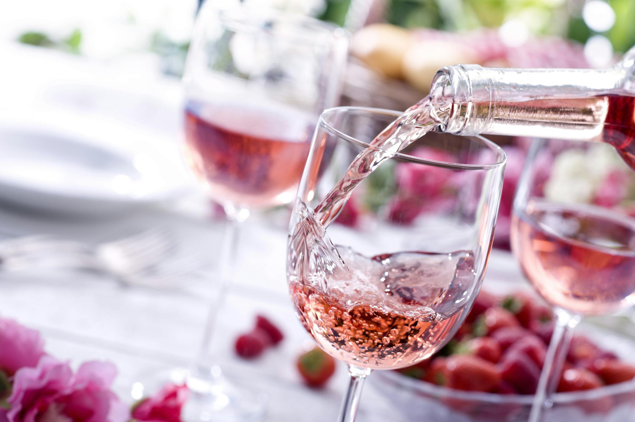 Close up of Rose wine being poured at a picnic setting. istock photo