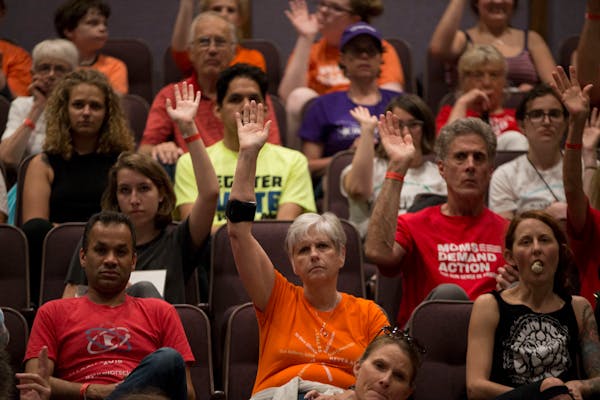 Audience members raise their hands in response to a student asking who knows someone who has been affected by gun violence.