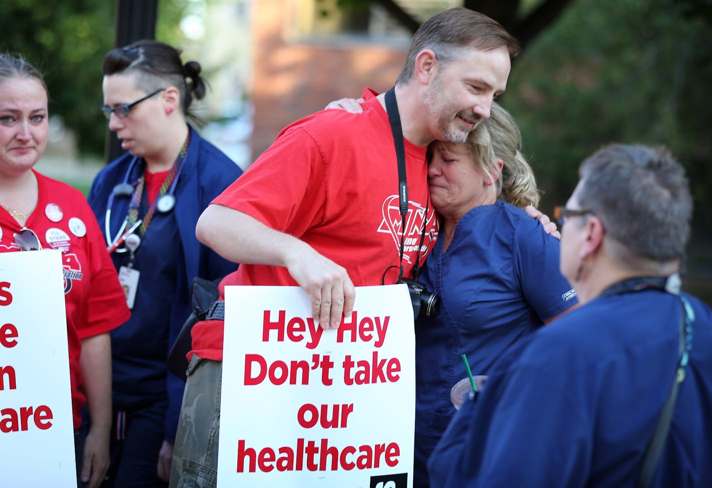 Nurse Shawn Deitz right, was hugged by a co-worker as she walked out of the Abbot Northwestern Hospital at the end of her shift at 7am, to join other nurse on the Pickett line Sunday June 19, 2016 in Minneapolis, MN.] Day One in the Allina Health nurses strike. Jerry Holt /Jerry.Holt@Startribune.com