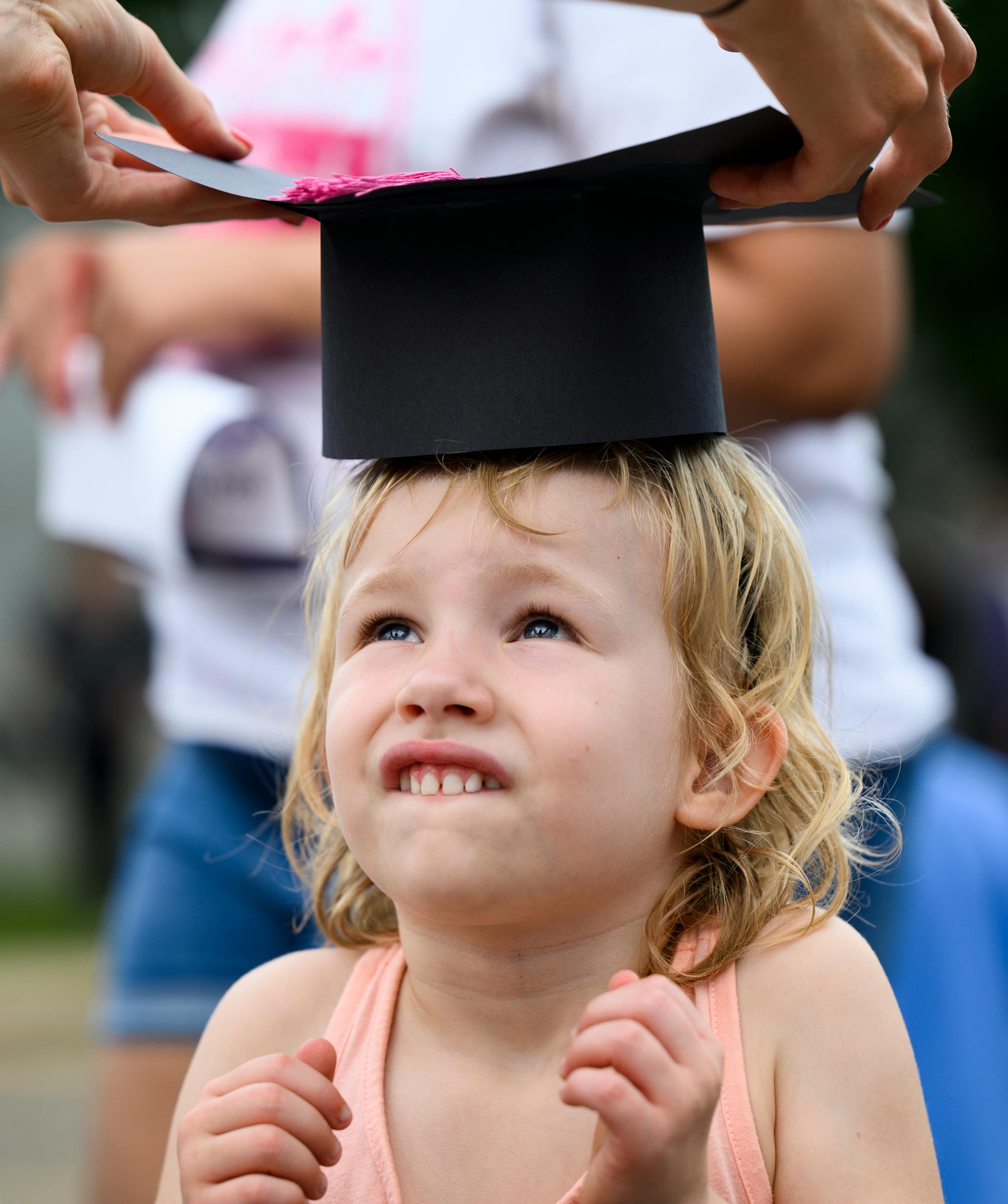 Lily Sand, with the MPS engagement department, places a graduation cap on the head of 5-year old Penny Knowlton during an early learners celebration for families with students 0-7 at Mona Moede Early Learning Center in Minneapolis.